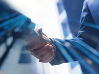 Two hands are shown clasped in agreement.