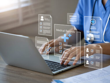 A doctor uses a laptop to manage electronic medical records.