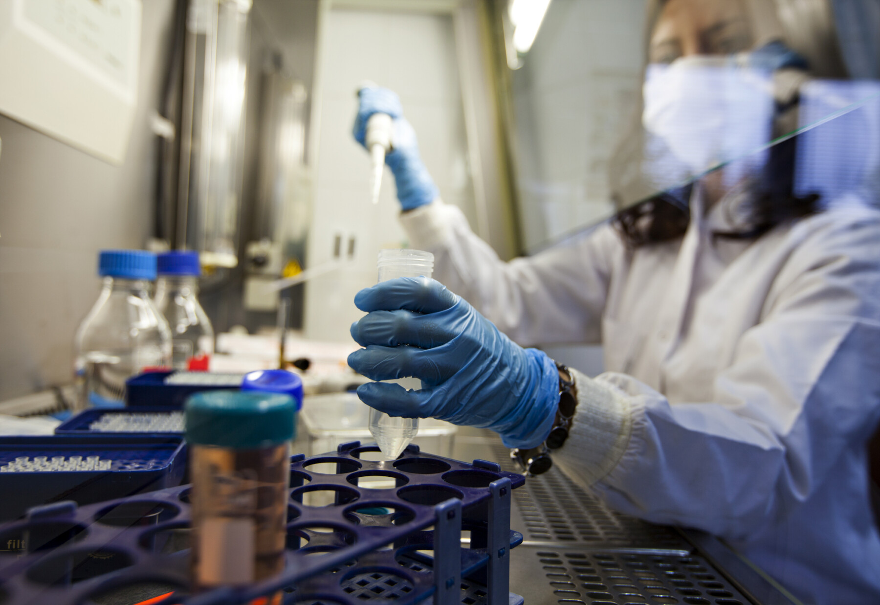 A photo shows a scientist holding a vial in a lab.