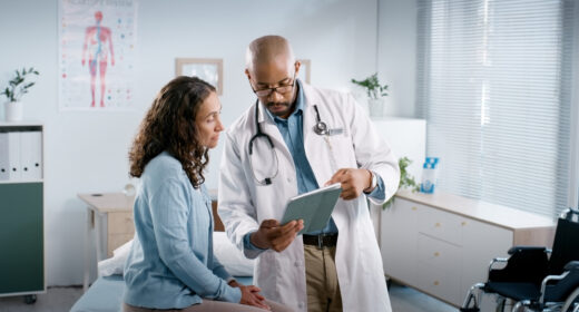 A doctor shows information on a tablet to a patient.