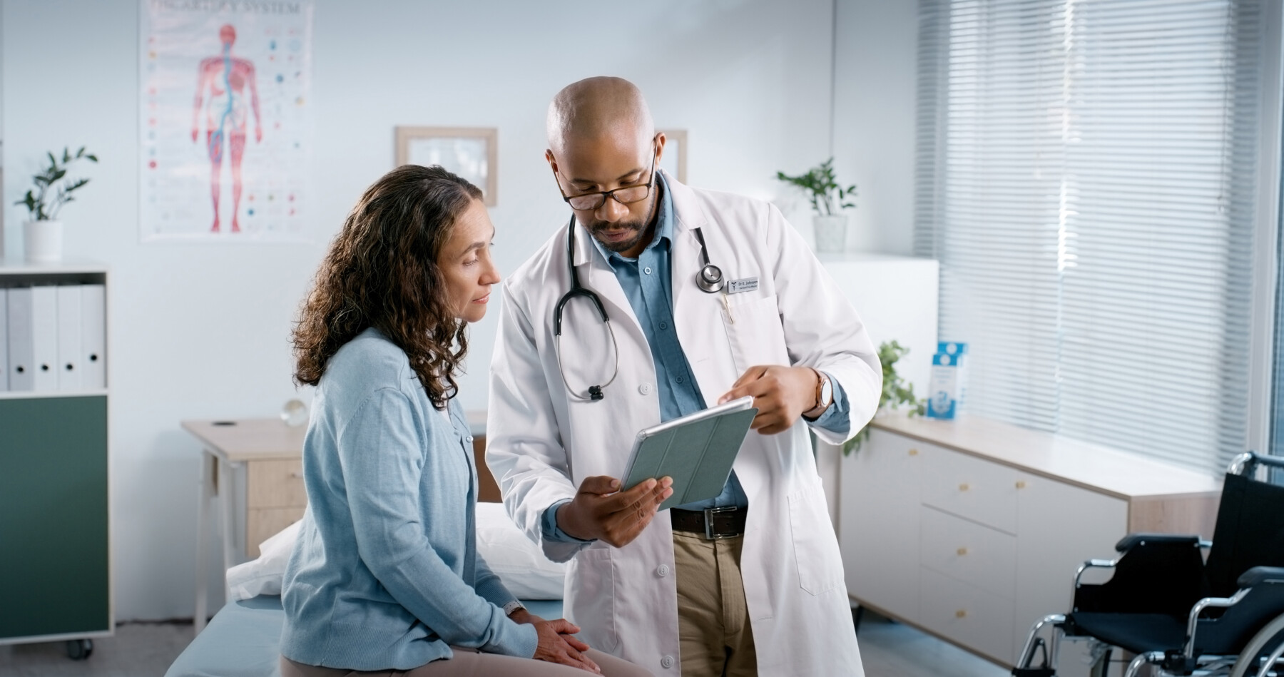 A doctor shows information on a tablet to a patient.