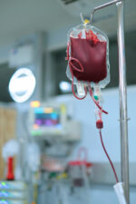 A bag of blood is hung on an infusion stand in a hospital care unit, ready for use in a patient.